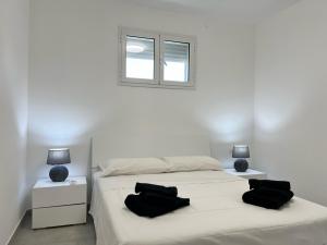 1 dormitorio con 1 cama con 2 almohadas negras en Marzamemi, Sul Livello del MARE, Spinazza en Marzamemi