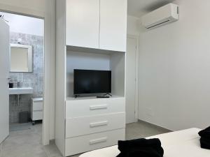 ein Schlafzimmer mit einem TV in einem weißen Schrank in der Unterkunft Marzamemi, Sul Livello del MARE, Spinazza in Marzamemi