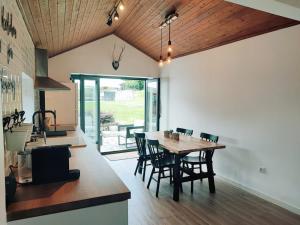 a kitchen and dining room with a wooden table and chairs at Casa de Gandra in Valença