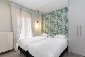 2 Betten in einem Zimmer mit Wandbild in der Unterkunft #Amazonia Apt by halu! Apartments in Thessaloniki