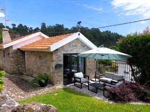 a house with two chairs and an umbrella at Casa de Gandra in Valença