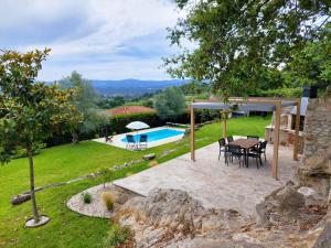 a patio with a table and chairs and a pool at Casa de Gandra in Valença