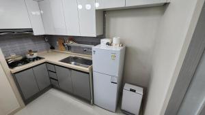 una pequeña cocina con nevera blanca y fregadero en lI - Full option two-room mountain view private house en Seúl