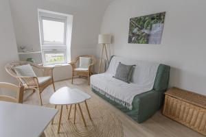 un soggiorno con divano e sedie verdi di Charmant duplex a Vannes