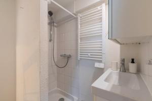 ein weißes Badezimmer mit Dusche und Waschbecken in der Unterkunft Appartement à côté de la Grand-Place in Lille