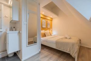 ein kleines Schlafzimmer mit einem Bett und einer Treppe in der Unterkunft Appartement à côté de la Grand-Place in Lille