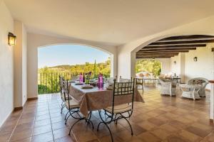 una sala da pranzo con tavolo e sedie e un balcone di Villa Pantanal in Golf Costa Brava a Santa Cristina d'Aro