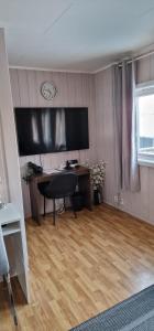 a room with a desk with a monitor and a chair at fjordRo in Båtsfjord