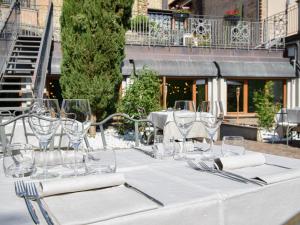 un tavolo con bicchieri da vino e tovaglioli sopra di Cora Aparthotel Stradivari a CastellʼArquato