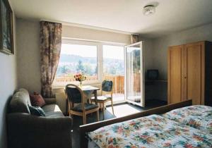 Schlafzimmer mit einem Bett, einem Tisch und einem Fenster in der Unterkunft Gasthaus Zum Spalterwald in Beerfelden