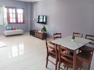 comedor con mesa y sillas y sala de estar en double storey cosy home pengkalan balak 5 aircond, en Pengkalan Balak