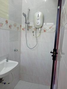 y baño con ducha y lavamanos. en double storey cosy home pengkalan balak 5 aircond, en Pengkalan Balak