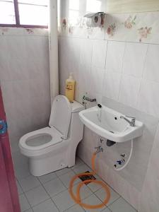 y baño con aseo y lavamanos. en double storey cosy home pengkalan balak 5 aircond, en Pengkalan Balak