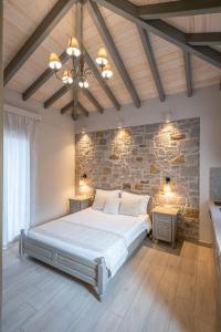 a bedroom with a large bed and a stone wall at AMYGDALIES STONE APARTMENTS in Myrina