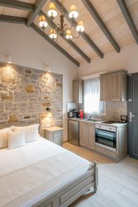 a bedroom with a large bed and a stone wall at AMYGDALIES STONE APARTMENTS in Myrina