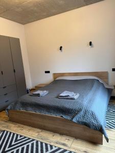 1 dormitorio con 1 cama con 2 toallas en Нові Loft Апартаменти 5 (центр-залізничний вокзал) en Ivano-Frankivsk