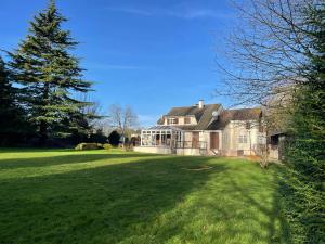 a large house with a large yard with a tree at La Follette in Beuzeville