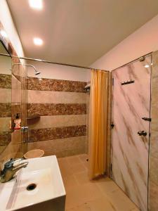 bagno con lavandino e doccia di HOTEL STEAM a Calcutta