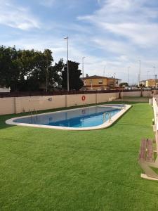ein Schwimmbad in einem Park mit grünem Gras in der Unterkunft Apartamento Bonita Vista in Vinarós