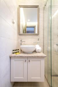 a bathroom with a sink and a mirror at AMYGDALIES STONE APARTMENTS in Myrina