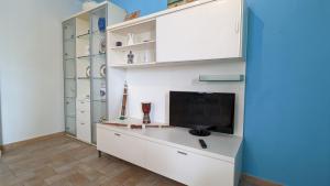 uma sala de estar com uma televisão num armário branco em Marzamemi, Sul Livello del MARE, GOLD em Marzamemi