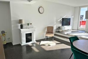 uma sala de estar branca com lareira e televisão em Isaak Appartment Stadtjuwel em Waldshut-Tiengen