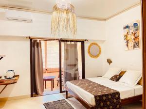 Un dormitorio con una cama y una lámpara de araña. en LE NOUVEL EDEN, en Toliara