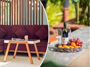 STAR HOLIDAY VILLAS في أنجونا: طاولة مع زجاجة من النبيذ وصحن من الفاكهة