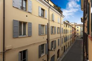 eine Gasse in einer Altstadt mit Fensterläden in der Unterkunft Rua Freda Apartments in Modena