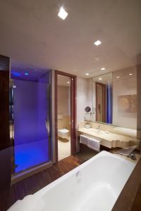 a bathroom with a tub and a sink and a mirror at San Paolo Hotel in Montegiorgio