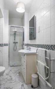 a white bathroom with a sink and a shower at South Inch Apartment in Perth