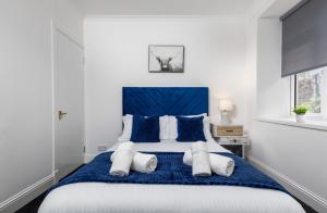 a bedroom with a blue and white bed with pillows at South Inch Apartment in Perth