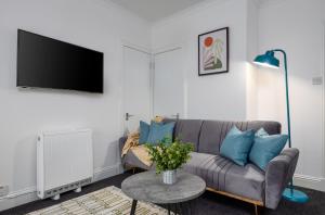a living room with a couch and a tv at South Inch Apartment in Perth