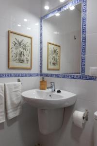 y baño con lavabo y espejo. en Apartamentos San Francisco, en Sevilla