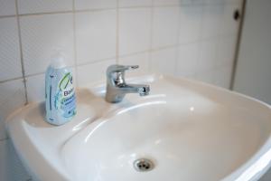 uma garrafa de pasta de dentes sentada no lavatório da casa de banho em ATRIUM - großzügige Apartment RHEINHORST RECHTS em Ludwigshafen am Rhein