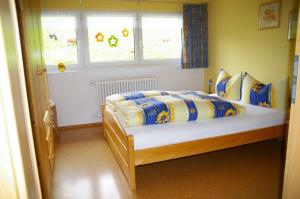 um quarto com uma cama num quarto com janelas em Dürrenbartleshof em Breitnau