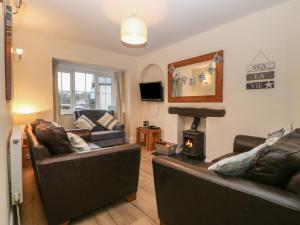 a living room with two leather couches and a fireplace at Castell in Pwllheli