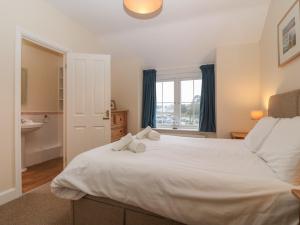 a bedroom with a large white bed with a window at Castell in Pwllheli