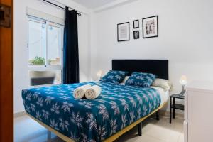 a bedroom with a bed with two towels on it at San Pagés 3BR Apartment in Seville