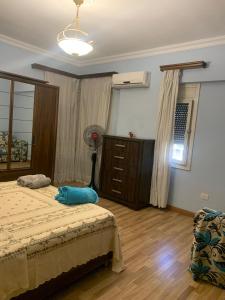 a bedroom with a bed and a dresser at Large Luxurious Apartment in Cairo