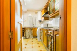 a kitchen with yellow cabinets and a floor at San Pagés 3BR Apartment in Seville