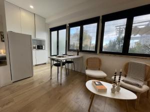 sala de estar con mesa, sillas y ventanas en Urban Terrace Apartment 1C, en Lisboa