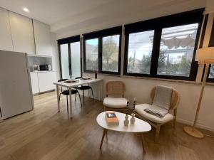 sala de estar con mesa, sillas y ventanas en Urban Terrace Apartment 1C, en Lisboa