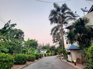 an empty street with palm trees and a building at Siam Boutique Hotel โรงแรมสยามบูทีค in Buriram