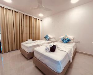 a hotel room with two beds and curtains at Boli Villa Thoddoo in Thoddoo