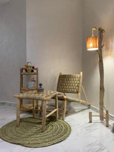 una camera con sedia, tavolo e lampada di appartement équipé a Tangeri