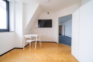 comedor blanco con mesa y TV en ATRIUM - großzügige Apartment RHEINHORST RECHTS, en Ludwigshafen am Rhein