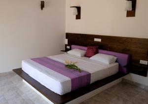 Sanda Eliya Resort في بينتوتا: غرفة نوم بها سرير كبير وعليه زهور