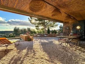 a large patio with a table and chairs and a table at Maison d'hôtes Les Oliviers in Cazouls-lès-Béziers