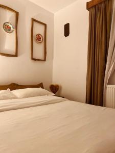 1 dormitorio con 1 cama y 2 platos en la pared en Cabana Bogdi en Borşa